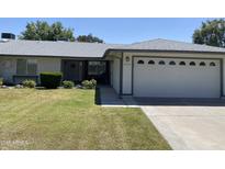 Ranch-style home with a two-car garage and well-maintained lawn at 4829 E Lake Point Cir, Phoenix, AZ 85044