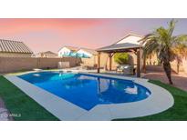 Relaxing pool area with a gazebo, comfortable seating, and surrounding landscaping at 9336 E Obispo Ave, Mesa, AZ 85212