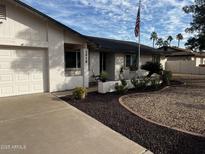 Charming single-story home featuring a landscaped front yard and an American flag at 2918 E Des Moines St, Mesa, AZ 85213