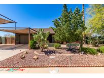 Charming single-story home showcasing xeriscaping, desert landscaping, and a covered carport for convenient parking at 548 N 82Nd St, Mesa, AZ 85207