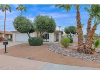 White brick ranch house with mature landscaping and a large driveway at 947 N 85Th Pl, Scottsdale, AZ 85257