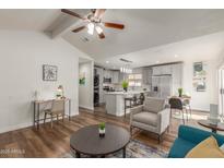 Bright living room with teal sofa and wood-look floors at 1171 E Vaughn St # A, Tempe, AZ 85283