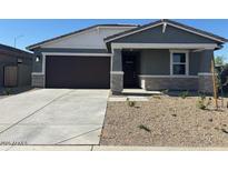 Charming single-story home featuring a two-car garage, stone accents, and low-maintenance landscaping at 22563 W Pontiac Dr, Surprise, AZ 85387