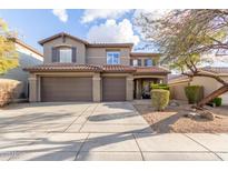 Two-story house with brown double garage doors and desert landscaping at 2527 W Kit Carson Trl, Phoenix, AZ 85086