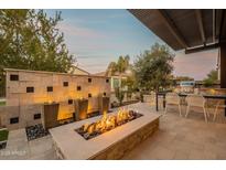 Back patio with a fire pit, decorative stone wall, and built in grill area perfect for outdoor entertaining at 290 E Tangerine Path, Queen Creek, AZ 85140