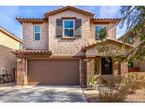Two-story house with brown brick, attached garage, and landscaping at 6943 N 88Th Dr, Glendale, AZ 85305