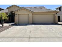 Tan home featuring a two-car garage, desert landscaping, and a tile roof, perfect for low-maintenance living at 861 E Toledo St, Gilbert, AZ 85295