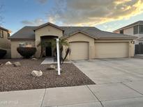 Single-story home featuring a low-maintenance desert landscape and an attached two-car garage at 861 E Toledo St, Gilbert, AZ 85295