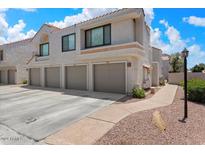 Condo exterior with three-car garage and landscaped walkway at 10115 E Mountain View Rd # 2065, Scottsdale, AZ 85258