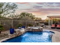 Stunning pool with waterfall feature, spa, and covered patio at 17679 W Redwood Ln, Goodyear, AZ 85338