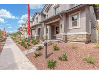 Charming townhome exterior with landscaped front, covered entry, and stone accents for added curb appeal at 2917 N Evergreen St, Buckeye, AZ 85396