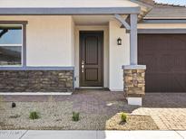 Inviting front entrance with stone accents, a dark wood door, and a well-maintained walkway at 4041 S 176Th Dr, Goodyear, AZ 85338