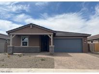 Charming single-story home featuring a covered porch, two car garage, and desert landscaping at 4822 N 177Th Ln, Goodyear, AZ 85395