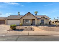 Tan one-story house with a two-car garage and landscaped yard at 6325 W Monterey Pl, Chandler, AZ 85226