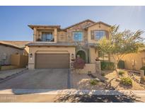 Two-story home with stone accents and a three-car garage at 9127 E Lynwood St, Mesa, AZ 85207