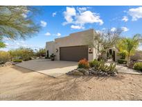 Spanish style home with landscaped desert front yard, large garage, and gated entry at 29305 N 146Th St, Scottsdale, AZ 85262