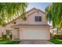 Two-story house with light pink siding, white garage door, and landscaped lawn at 441 S Maple -- # 13, Mesa, AZ 85206