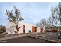 Stunning modern home featuring a sleek white exterior, natural landscaping, and wooden door at 10025 N 39Th St, Phoenix, AZ 85028