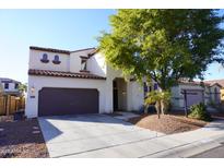 Two-story house with a brown door and attached garage, desert landscaping at 14740 N 173Rd Ln, Surprise, AZ 85388