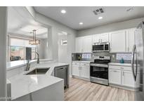 Modern kitchen featuring white cabinets, stainless steel appliances, and quartz countertops at 1873 W Dion Dr, Anthem, AZ 85086