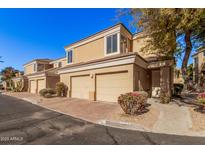 Tan two-story townhome with two-car garage and landscaping at 7887 N 16Th St # 224, Phoenix, AZ 85020