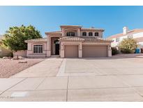 Two-story house with beige exterior, three car garage, and landscaped front yard at 14026 S 34Th St, Phoenix, AZ 85044