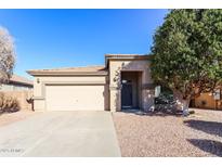 Single-story home with attached garage and landscaped front yard at 15930 W Redfield Rd, Surprise, AZ 85379