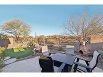 Relaxing backyard with putting green, patio furniture, and fire pit at 1610 W Owens Way, Anthem, AZ 85086