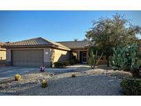Single-story home with a two-car garage and drought-tolerant landscaping at 17561 N Saddle Ridge Dr, Surprise, AZ 85374