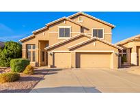 Two-story house with tan exterior, two-car garage, and landscaping at 8962 W Adam Ave, Peoria, AZ 85382