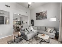 Spacious living room featuring a comfortable sectional sofa and large windows at 1942 W Davis Rd, Phoenix, AZ 85023