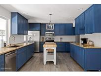 Modern kitchen with blue cabinets, granite counters, and island at 3126 N 84Th Pl, Scottsdale, AZ 85251