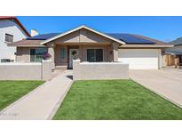 Charming home with a well-kept lawn, solar panels, and a welcoming front entrance, perfect for families at 6352 W Campo Bello Dr, Glendale, AZ 85308