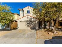 Two-story house with tan exterior, and a two-car garage at 9442 W Palm Ln, Phoenix, AZ 85037