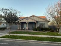 One-story home with gray garage door, covered porch, and landscaped yard at 4288 E Comstock Dr, Gilbert, AZ 85296