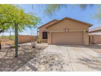 Tan house with a two-car garage and desert landscaping at 6416 E Hacienda La Noria Ln, Gold Canyon, AZ 85118