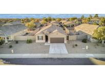 Aerial view of a single-story house with a brown garage door and a landscaped yard at 36091 W Seville Dr, Maricopa, AZ 85138