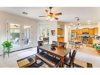 Bright dining room with wood table and access to the kitchen and backyard at 18187 W Wind Song Ave, Goodyear, AZ 85338