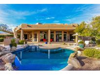 Inviting pool with spacious patio, mature landscaping, and a covered patio at 19007 E Lazo Ct, Rio Verde, AZ 85263