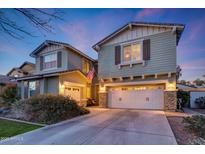 Two-story house with a large white garage door and landscaping at 20744 W Hamilton St, Buckeye, AZ 85396