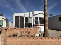 Single-wide manufactured home with landscaped yard and brick border at 2358 S Pomo Ave, Apache Junction, AZ 85119