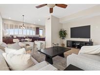 Bright living room with neutral color palette, modern furniture, ceiling fan, and view into kitchen area at 2742 N Augustine --, Mesa, AZ 85207