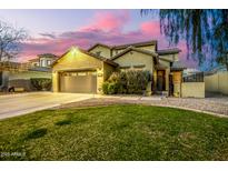 Charming two-story home with well-manicured front yard and desert landscaping at dusk at 4332 E Vallejo Ct, Gilbert, AZ 85298