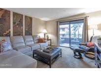 Bright living room with comfy seating and access to a private balcony at 4704 E Paradise Village N Pkwy # 239, Phoenix, AZ 85032