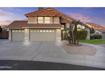 Charming two-story home featuring a three-car garage, red tile roof, and mature landscaping at 7804 W Pershing Ave, Peoria, AZ 85381