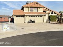 Charming home featuring a terracotta tile roof, three car garage, and neatly maintained landscaping at 7804 W Pershing Ave, Peoria, AZ 85381