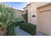 Tan house with lush landscaping and a two-car garage at 1942 W Peninsula Cir, Chandler, AZ 85248