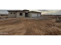 A single-story stucco home with a two car garage and desert landscaping at 25519 W Brookhart Way, Wittmann, AZ 85361