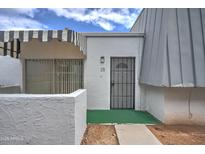 Front view of a condo with a striped awning, green walkway, and a gray metal door at 3416 N 44Th St # 35, Phoenix, AZ 85018