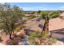 House with solar panels on the roof, showcasing a neighborhood view at 10387 W Runion Dr, Peoria, AZ 85382